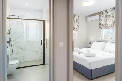 a bedroom with a bed and a bathroom with a shower at IVY Apartments in the Heart of Athens in Athens