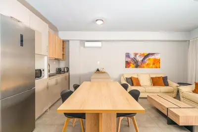 a kitchen and living room with a wooden table in a room at IVY Apartments in the Heart of Athens in Athens