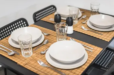 a table set with white plates and glasses and silverware at Athens Central Pangrati - Varnava Square Modern Apartment for 5 in Athens