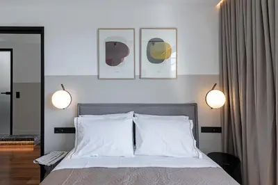 a bedroom with a bed with three pictures on the wall at The Athenians Art Apartments in Athens