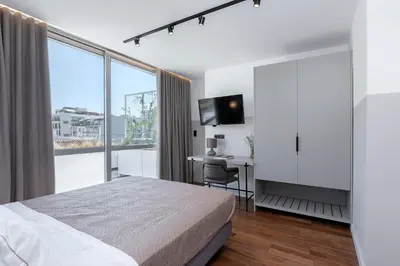a bedroom with a bed and a desk and a window at The Athenians Art Apartments in Athens