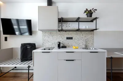 a kitchen with white cabinets and a sink at The Athenians Art Apartments in Athens