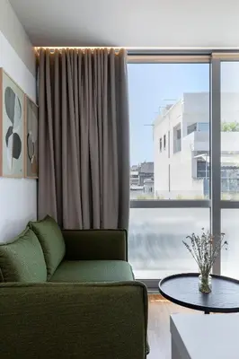 a living room with a couch and a large window at The Athenians Art Apartments in Athens
