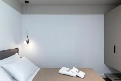 a bedroom with a bed with two towels on it at The Athenians Art Apartments in Athens