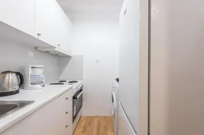 a white kitchen with a sink and a stove at Apartment at Megaro Mousikis st semi basement 1bed 2 pers by MPS in Athens