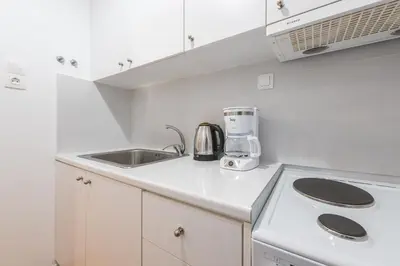 a white kitchen with a sink and a appliance at Apartment at Megaro Mousikis st semi basement 1bed 2 pers by MPS in Athens