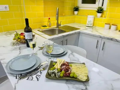 a plate of food on a kitchen counter with wine glasses at Lemoni Garden Apartment VIPGreece in Athens