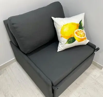 a gray couch with a lemon pillow on it at Lemoni Garden Apartment VIPGreece in Athens