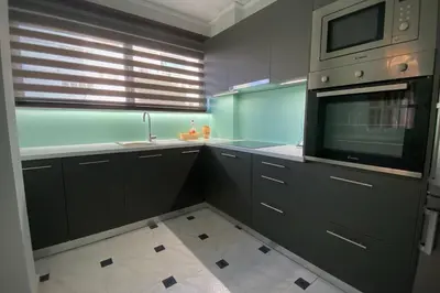 a kitchen with black cabinets and a microwave at MyAcropolis in Athens