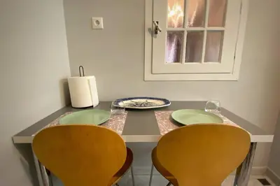 a table with two chairs and green plates and a window at MyAcropolis in Athens