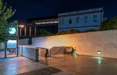 a group of benches next to a wall at night at Entire Apartment - Heart of Athens in Athens