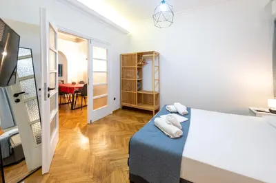 a bedroom with a bed and a dining room at Entire Apartment - Heart of Athens in Athens