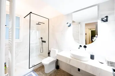 a white bathroom with a sink and a shower at Entire Apartment - Heart of Athens in Athens