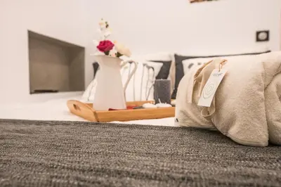 a bed with a pillow and a vase on it at Athenian Living Suites in Athens