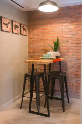 a table with stools in front of a brick wall at Athenian Living Suites in Athens