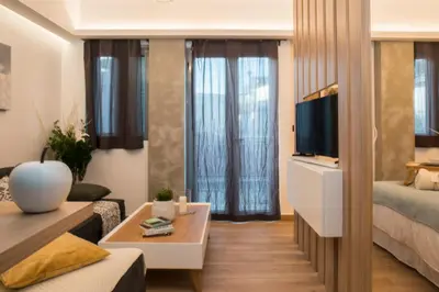a small living room with a bed and a tv at Athenian Living Suites in Athens