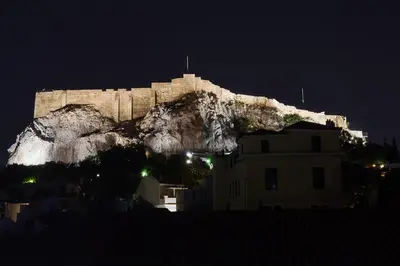 a castle sitting on top of a mountain at night at 105 Adrianou Plaka in Athens