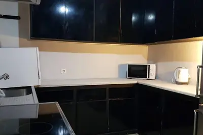 a kitchen with black cabinets and a microwave on a counter at Double Apartment - Athens Center, 7 BD, 3 BATH in Athens
