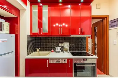 a kitchen with red cabinets and a sink at Athens Strawberry Hideaway - City Cozy Gem in Athens