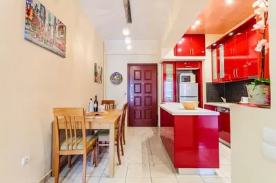 a kitchen with red cabinets and a table and a dining room at Athens Strawberry Hideaway - City Cozy Gem in Athens