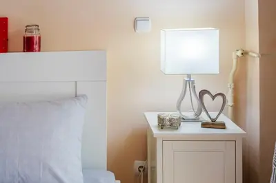 a lamp on a night stand next to a bed at Athens Strawberry Hideaway - City Cozy Gem in Athens