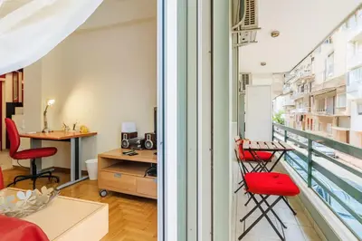 a room with a balcony with red chairs and a desk at Athens Strawberry Hideaway - City Cozy Gem in Athens