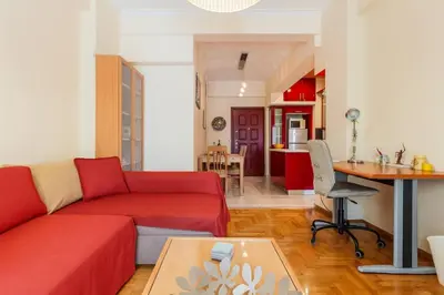 a living room with a red couch and a table at Athens Strawberry Hideaway - City Cozy Gem in Athens