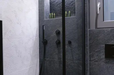 a bathroom with a shower with a glass door at Adrianou at Heart of Plaka in Athens