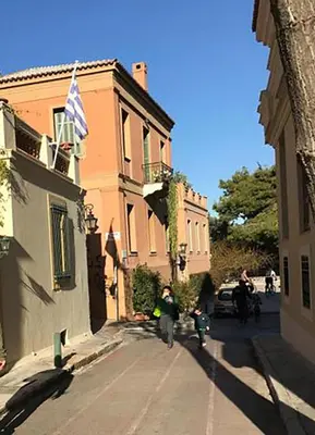 a group of people walking down a street next to a building at Adrianou at Heart of Plaka in Athens