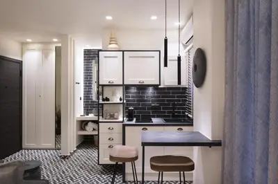 a kitchen with white cabinets and a table and stools at Adrianou at Heart of Plaka in Athens