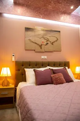 a bedroom with a large bed and a painting on the wall at Athens Nautical Flat in Piraeus