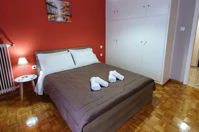 a bedroom with a bed with two white slippers on it at Greek hospitality in a modern apartment in Athens