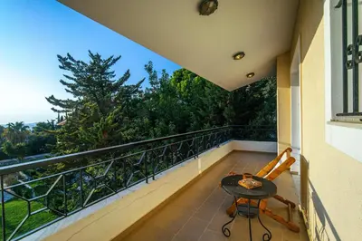 a balcony with a table and a chair on a balcony at VILLA ELENI in Anavissos