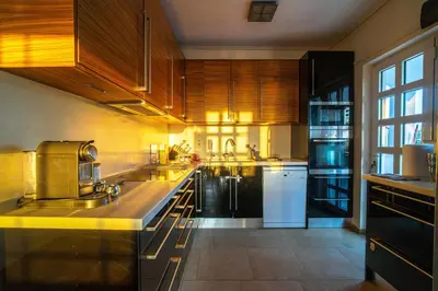 a large kitchen with wooden cabinets and white appliances at VILLA ELENI in Anavissos
