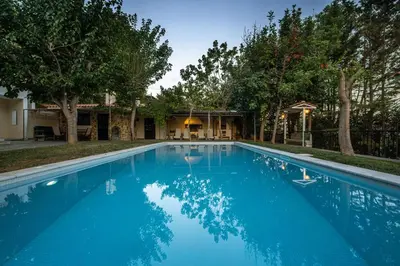 a large blue swimming pool in front of a house at VILLA ELENI in Anavissos