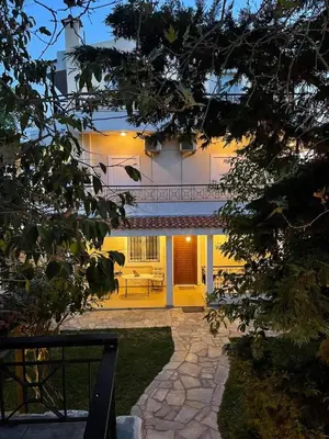 a house with a stone walkway in front of it at VILLA ELENI in Anavissos