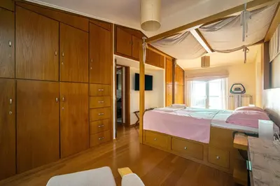 a bedroom with a large bed and wooden cabinets at VILLA ELENI in Anavissos