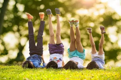 a group of people laying on the grass with their hands in the air at VILLA ELENI in Anavissos