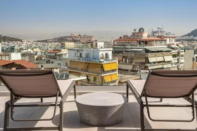 two chairs and a table on a balcony overlooking a city at ☆Acropolis View Villa☆Free Cancellation☆Rooftop Terrace☆ in Athens