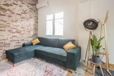 a living room with a blue couch and a brick wall at ☆Acropolis View Villa☆Free Cancellation☆Rooftop Terrace☆ in Athens