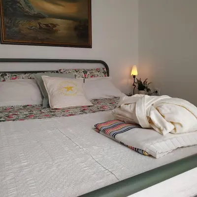 a white bed with a blanket on top of it at House Sleeps 4 with Pets in Kalívia Thorikoú
