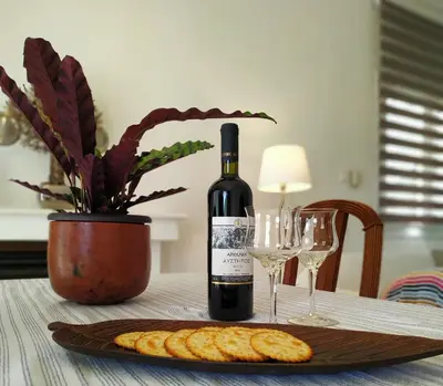 a bottle of wine and wine glasses on a table at House Sleeps 4 with Pets in Kalívia Thorikoú