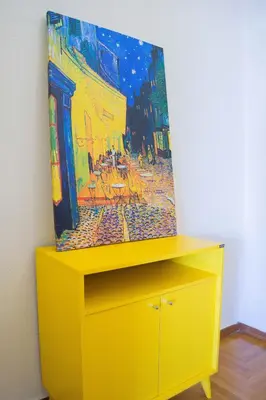 a yellow dresser with a painting on top of it at Athens Colors Suite in Athens