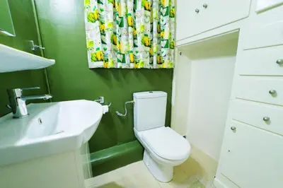 a bathroom with a white toilet and a sink at Athens Colors Suite in Athens