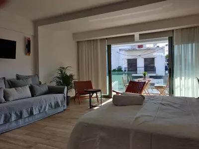 a living room with a bed and a couch and a patio at Sunny lovely apartment 60 meters from the metro in Athens