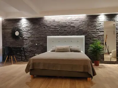 a bedroom with a large bed and a brick wall at Sunny lovely apartment 60 meters from the metro in Athens