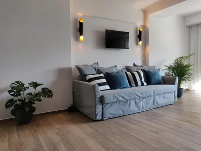 a living room with a couch with pillows on it at Sunny lovely apartment 60 meters from the metro in Athens