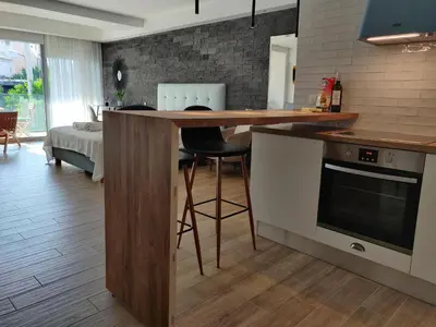 a kitchen with a counter and a bar with chairs at Sunny lovely apartment 60 meters from the metro in Athens