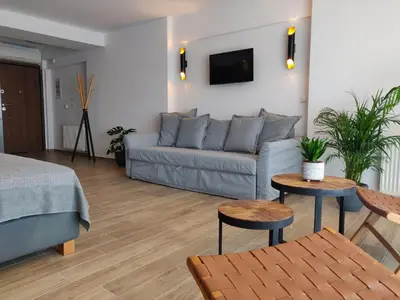 a living room with a couch and two tables at Sunny lovely apartment 60 meters from the metro in Athens