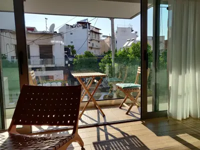 a balcony with a chair and a table on a balcony at Sunny lovely apartment 60 meters from the metro in Athens